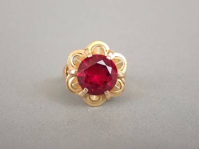 Gros plan sur une bague en or ornée d'une pierre rouge
