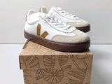 white and brown vejaa sneakers on top of a cardboard box