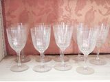 six wine glasses sitting on a shelf in a room