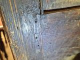 a close up of a wooden table with a chair in the background