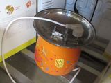 an orange bucket with a handle sitting on a shelf next to a box of food