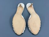 la semelle d'une paire de chaussures blanches posée sur une surface bleue