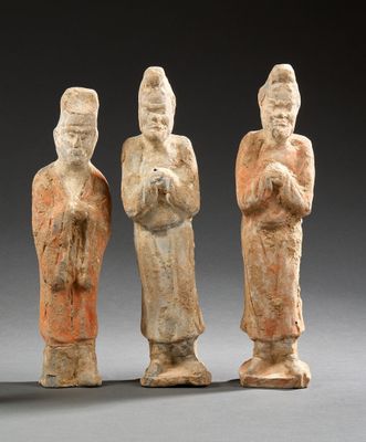trois figurines anciennes représentant trois hommes debout côte à côte