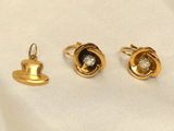 three pairs of gold and diamond earrings on a white cloth