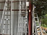 de nombreuses échelles appuyées contre la façade d'un immeuble