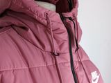 a close up of a pink jacket with a hood and zippers