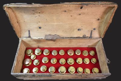 une boîte en bois contenant un paquet de pièces d'or