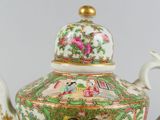 a tea pot with a lid that has a painting on it