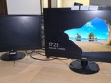 deux écrans d'ordinateur posés sur une table, avec un clavier et une souris