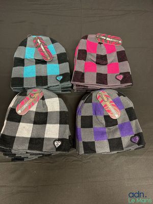 four beanies with tags on them sitting on a table