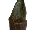 statue of a woman sitting on a wooden block with a white background