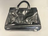 a black leather handbag sitting on top of a white table