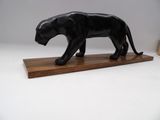 statue d'une panthère noire posée sur un socle en bois