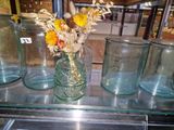 many glass jars with flowers in them on a shelf