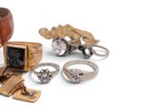 a lot of rings and other jewelry on a white surface