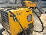 a couple of yellow machines sitting on top of a pile of wood