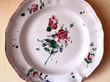 a white plate with red and pink flowers on it