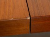 a close up of a wooden table with a piece of wood sticking out of it