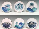 four plates with different designs on them on a white surface
