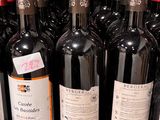 Des bouteilles de vin rouge sont alignées sur une étagère dans un magasin