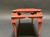 a small orange table with two legs and a drawer on top