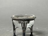 an antique silver plated bowl on a stand on a gray background