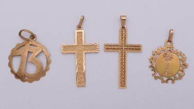 three gold crosses and a cross pendant on a white background