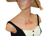 woman wearing a black and white dress and a straw hat with red writing on it