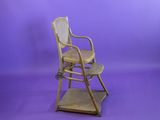 a wooden high chair with a wicker seat on a purple background