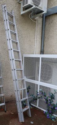 two ladders leaning against a wall next to a window