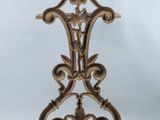 an antique cast iron clock on a stand with a white background