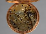 a close up of a gold pocket watch on a stand