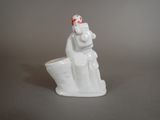 a white figurine of a woman with a bird on her head
