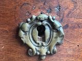 a metal knob on a wooden table that has holes in it