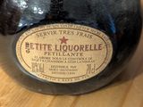 a bottle of liquor sitting on a table next to a bottle of wine