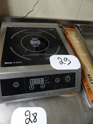 un plan de travail en acier inoxydable équipé d'une cuisinière électrique et d'un plateau de beignets