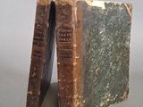 un vieux livre posé sur une table, à côté de deux autres livres