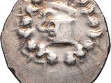 a silver coin with a face on it on a white background