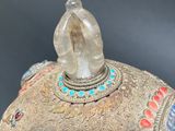 a silver vase with a crystal in it on a table