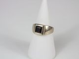 a close up of a ring with a black stone on it