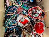 une boîte en carton remplie de bijoux variés et d'autres objets
