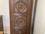a tall wooden cabinet in the corner of a room