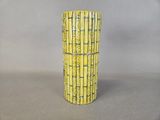 a tall yellow vase sitting on a table
