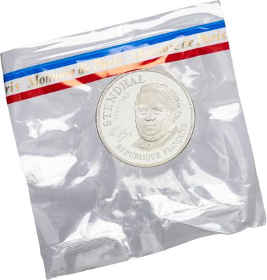 a close up of a coin in a plastic bag on a white background