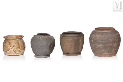Plusieurs vases sont alignés sur une surface blanche