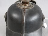 a helmet with a bell on top of it on a white surface