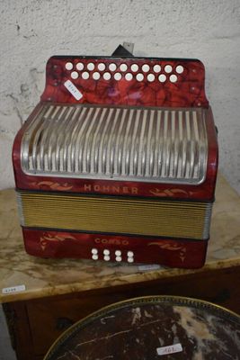 a red accordion sitting on top of a wooden table