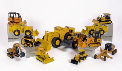 de nombreux engins de chantier miniatures posés sur une surface blanche