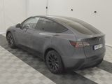 the tesla model y is parked in a garage with a checkered floor