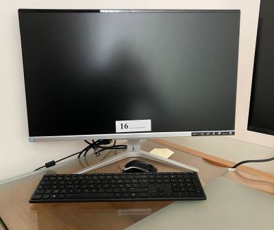 a computer monitor and keyboard on a desk in front of a monitor